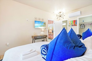 Une chambre d’hôtel équipée d’un lit, d’un bureau, d’une chaise, d’une télévision et d’une armoire.