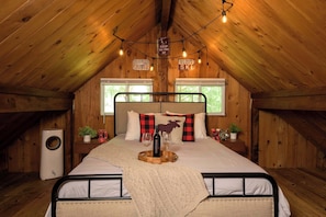 Um quarto de sótão aconchegante com cama, paredes de madeira, uma janela, aquecedor e um aviso com dicas de esqui.