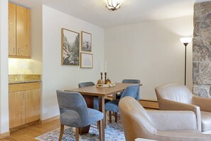 Een eetgedeelte met een tafel, stoelen en een stenen muur.
