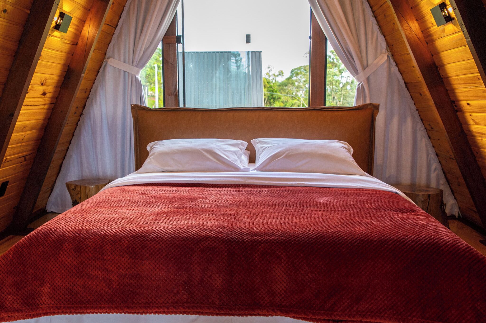 A room with a bed, a window, and curtains.