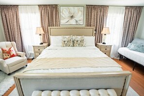 A bedroom with a large bed, two bedside tables, a chair, and a sofa. - 5 Mins to Arrowhead | 3BR KC Retreat | 3 Ensuites, Sauna & Theater (Independence)