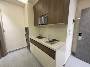 Eine moderne Küche mit Einbauofen, Edelstahl-Spüle und Holzschränken.