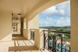 A corridor with a view of a green landscape and a clear sky. - PC404A-Pool View-Perfect for family or a group-Close to Palm Beach-3BR (Palm Beach)