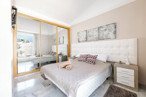 Ein Schlafzimmer mit einem Bett, einem Nachttisch, einem Spiegel und Bildern an der Wand.