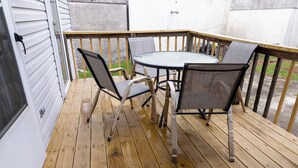 En træterrasse med et rundt bord og fire stole.