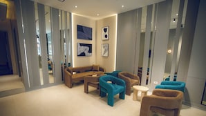 Un espace de détente moderne comprenant un canapé, des fauteuils et une petite table.