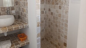 Ein Badezimmer mit Dusche, Waschbecken und Spiegel.