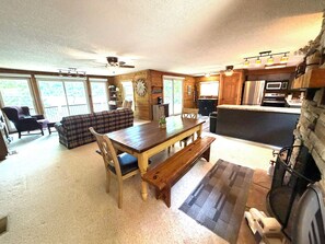 A cozy cabin interior with a dining area, kitchen, and living room.