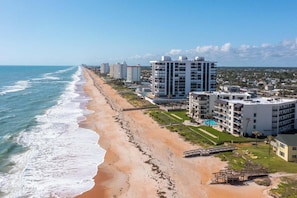 Ein Hotel an der Küste mit mehreren Etagen, Blick auf den Strand und einem Swimmingpool.