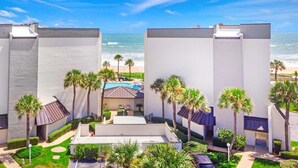 Een modern hotel met meerlaags gebouwen, een zwembad en uitzicht op het strand.