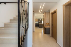 Ein modernes Interieur mit Treppe, Küchenbereich und Holztür.