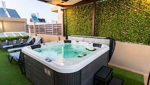 A hot tub with a control panel, surrounded by lounge chairs and a green wall. - Fems Luxury 3-level Home w Private Jacuzzi (Heraklion)