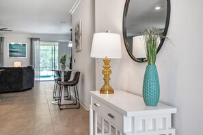 A modern interior with a white console table, a gold lamp, a teal vase, and a large mirror. - Game Room/SPA/Themed Bedrooms/Storey Lake 22088 (Kissimmee)