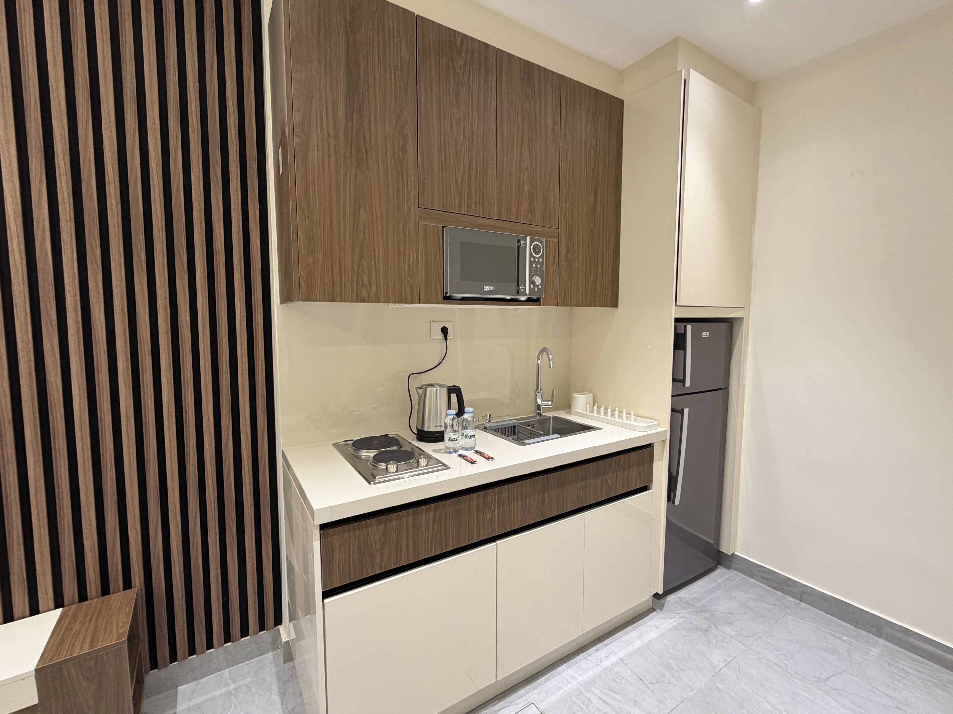 Una cocina moderna equipada con microondas, lavamanos, estufa y refrigerador.