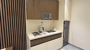 Une cuisine moderne équipée d’un four à micro-ondes, d’un évier, d’une cuisinière et d’un réfrigérateur.