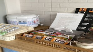 A kitchen counter with a rice cooker, a menu, and packaged food items. - Cozzy Penny House Private Pool (BATU)