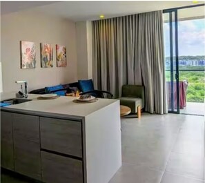 A modern kitchen with a central island, a dining area with a sofa and chairs, and a large sliding glass door leading to a balcony. - Apartment in Manzanillo, Cartagena, with direct beach access (Bolívar)