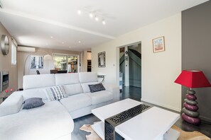 Un salon moderne avec un canapé, une table basse et une lampe rouge.