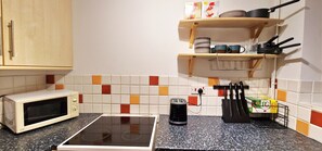 Eine Küche mit einer Mikrowelle, einem Toaster und einem Wasserkocher auf der Arbeitsfläche.