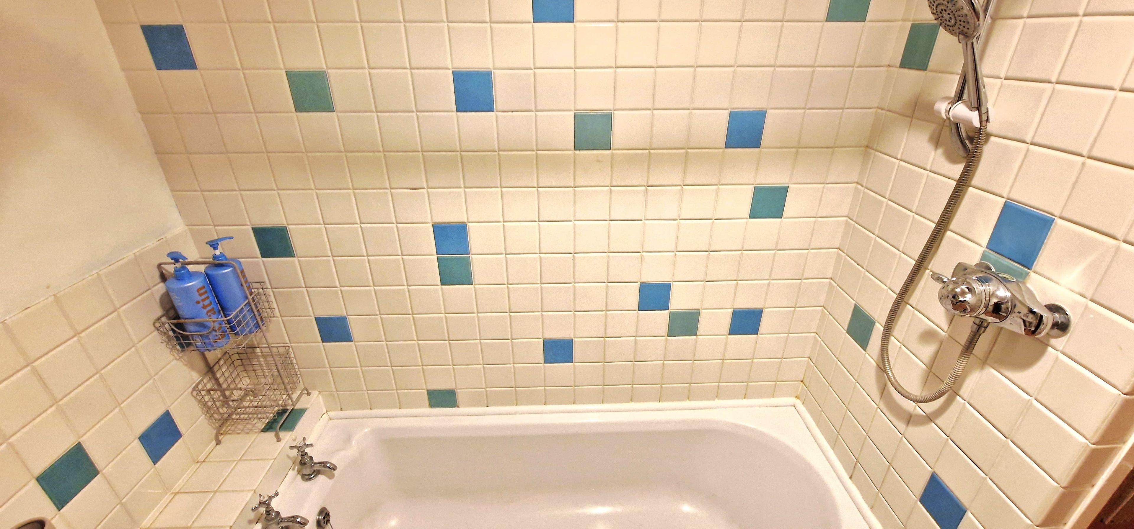 Un baño con bañera, ducha y secador de manos.