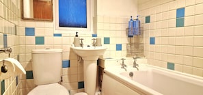 A bathroom with a toilet, sink, and bathtub.
