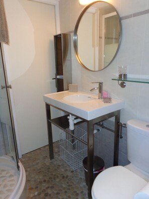 Een douche, handdoeken, zeep, toiletpapier