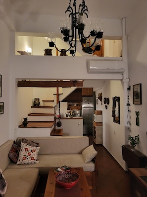 Ein Loft-Wohnraum mit Küche, einer Chandelieber und einem Sofa.