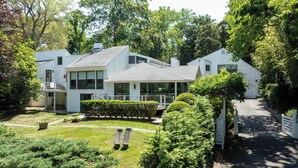 A modern two-story house with a covered porch, a small garden, and a driveway. - Dumar Villa by Rove - 6BR Family Home With Pool & Outdoor Spaces (Sag Harbor)