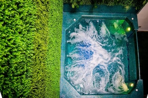 A hot tub with a green moss-like texture surrounding it. - 11br Pool Jacuzzi Eventsok Parque Lleras Provenza (Medellín)