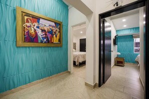 A hotel room with a bed, a nightstand, a painting, and a bathroom with a blue curtain. - 11br Pool Jacuzzi Eventsok Parque Lleras Provenza (Medellín)