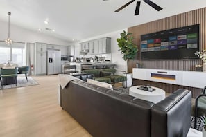 Ein modernes Wohnzimmer mit einer Couch, einem Couchtisch und einem Fernseher.