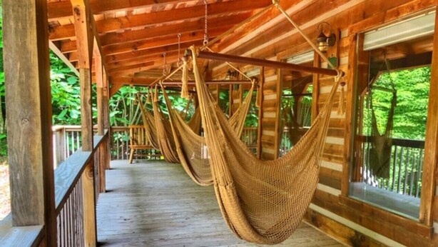Eine Holterrasse mit von der Decke hängenden Hängematten.