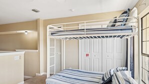 A bunk bed room with a desk and wardrobe, a fire exit sign, and a window. - Horizon South 55-304 (Panama City Beach)