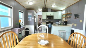 A compact kitchen with a central island, a dining table, and chairs. - Isle Always Luv View 2BR 1277 (Jensen Beach)