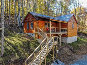 Eine Holzhütte mit einer Terrasse und Treppen, die zu einer zweiten Ebene führen.