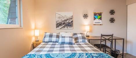 Une chambre à coucher comprenant un lit, deux tables de chevet, une chaise, un bureau et des éléments de décoration murale.