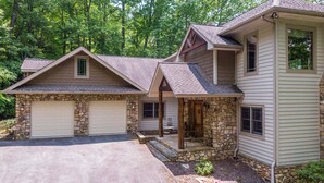 A two-story house with a stone foundation, a garage, and a covered porch. - Amitola at Yonahlossee (Boone)