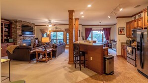 A spacious living room with a fireplace, a large TV, and a cozy seating area. - Caribou Crossing at The Lodges at Elkmont (Banner Elk)