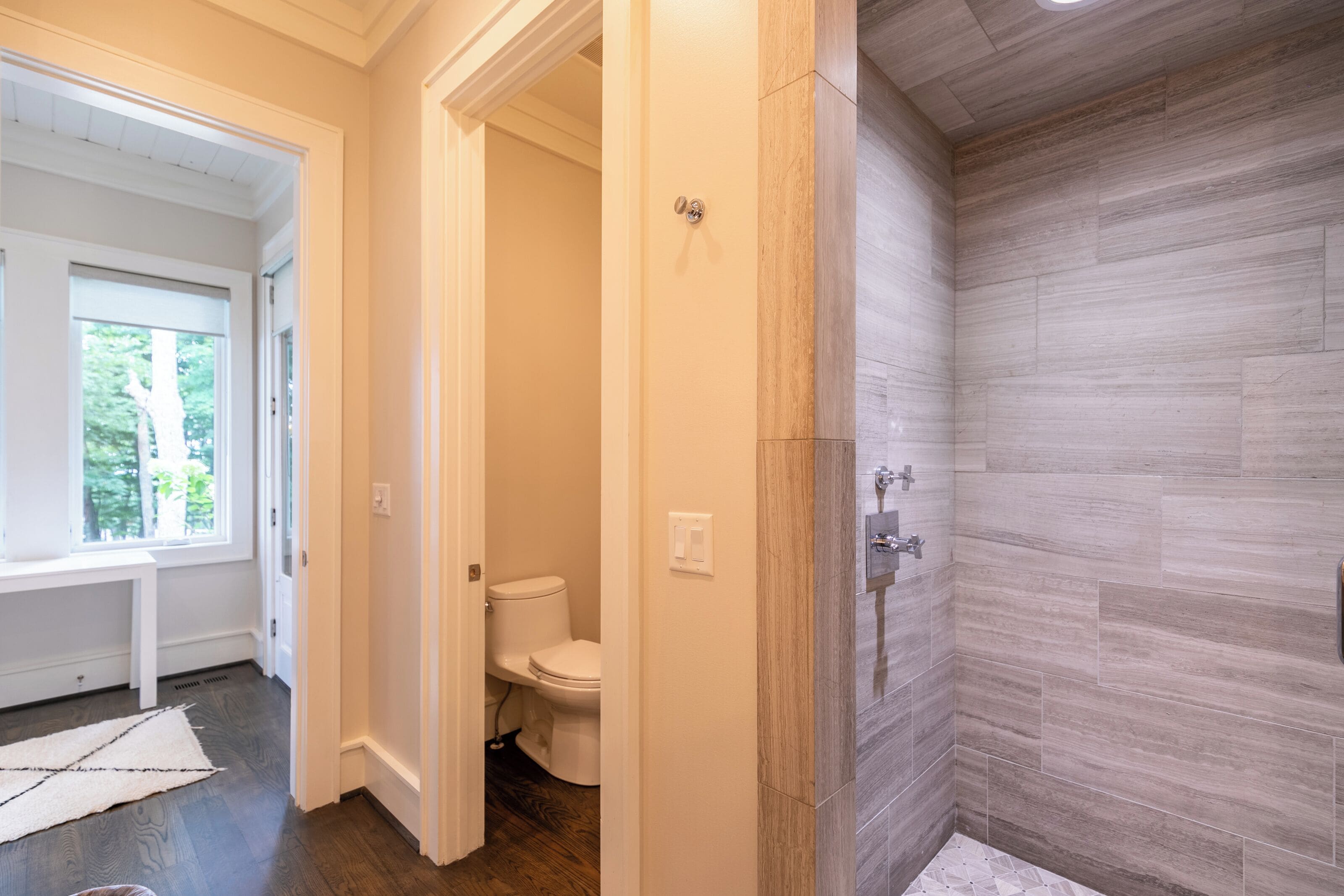 Ein modernes Badezimmer mit Dusche, Toilette und Fenster.