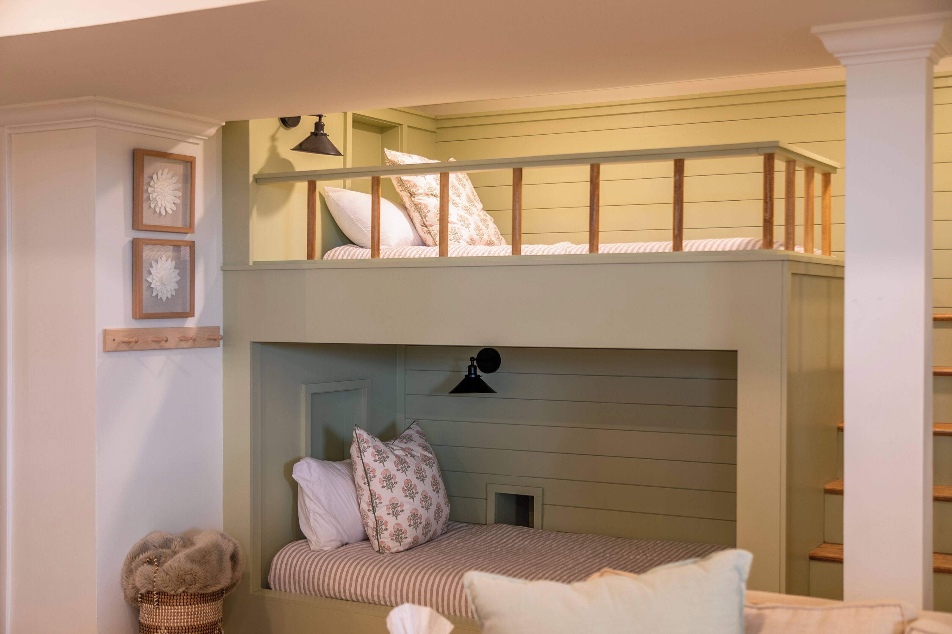 A bunk bed with a headboard, a small window, and a wall-mounted lamp.