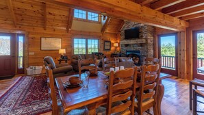 A spacious wooden cabin with a dining area, fireplace, and large windows. - Good Medicine (Boone)