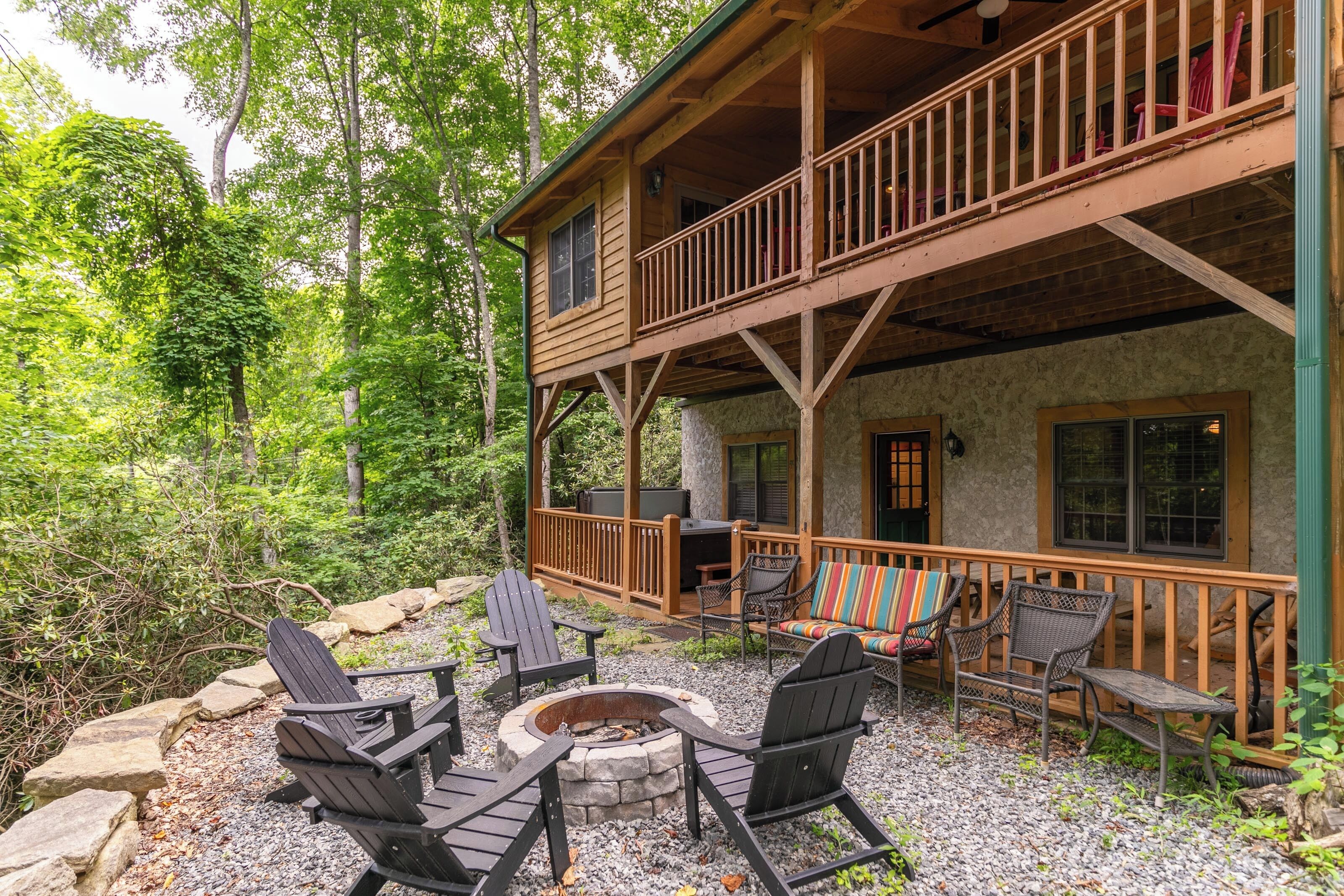 A cabin with a deck, outdoor seating, and a fire pit.