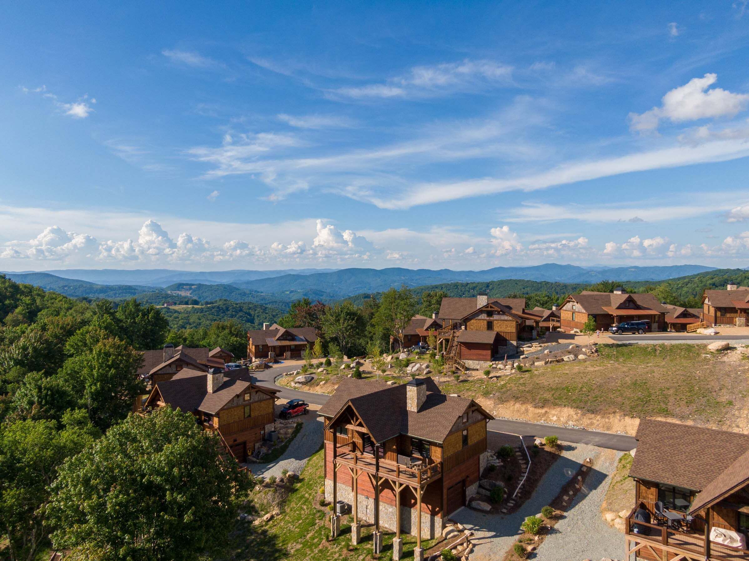 A lodge with multiple cabins, a central building, and a scenic mountain backdrop.
