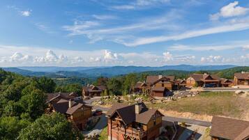 A lodge with multiple cabins, a central building, and a scenic mountain backdrop.