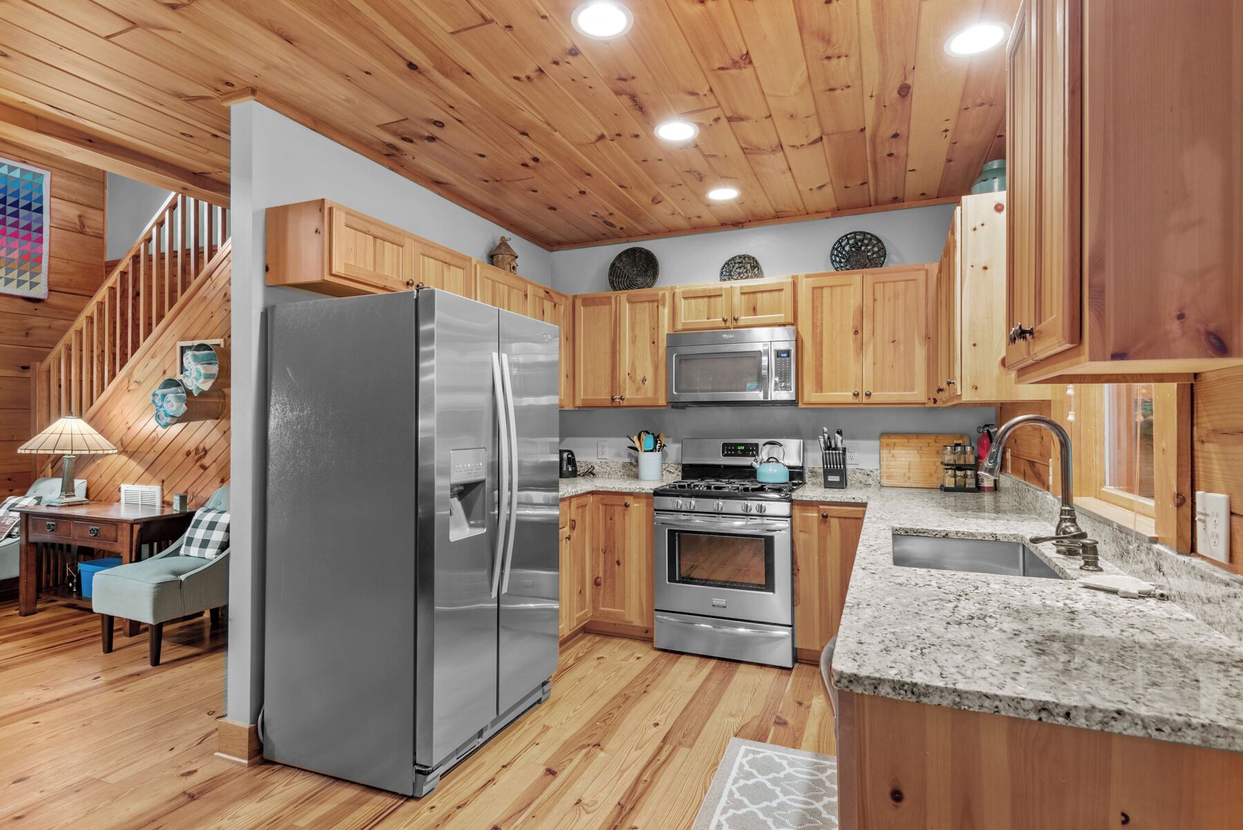 Una cocina moderna con armarios de madera, electrodomésticos de acero inoxidable y encimera de granito.