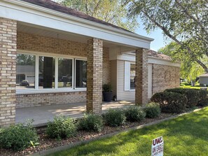 A two-story house with a brick facade, large windows, and a covered porch. - EAA Destination Home!  3 bedroom 2 1/2 bath and just 15 minutes from EAA! (Neenah)