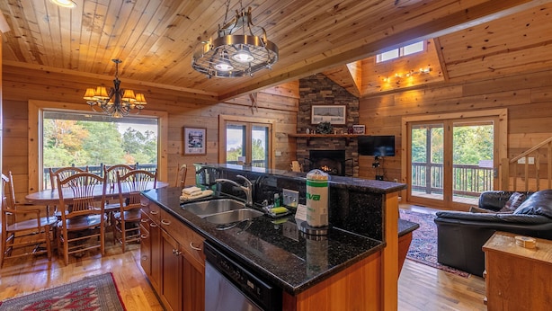 A wooden cabin interior with a kitchen, dining area, and living room. - Morris Cabin (Boone)