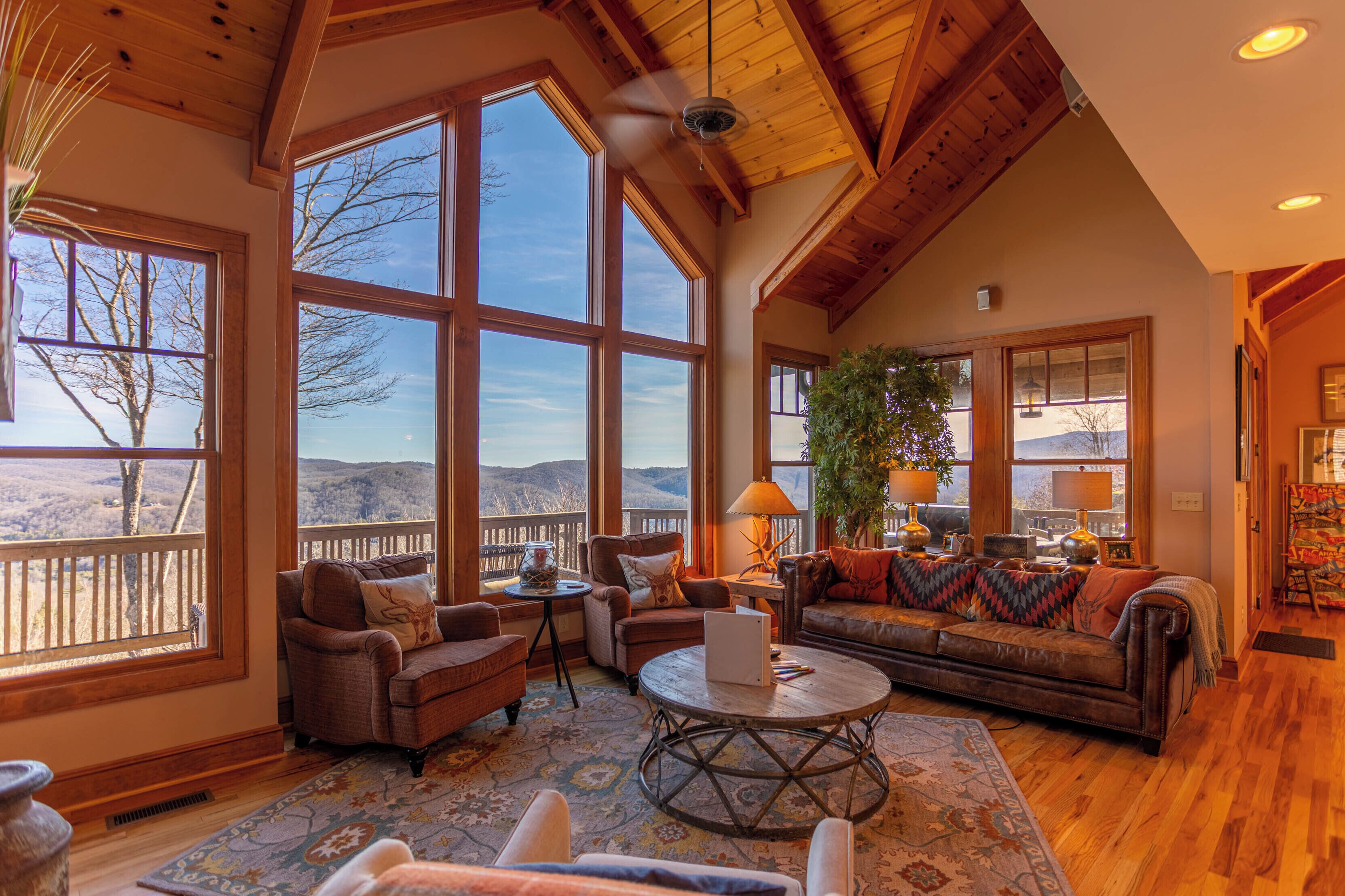 A spacious living room with large windows, a fireplace, and a cozy seating area.