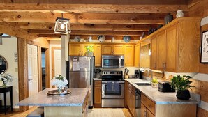 Una cocina moderna con armarios de madera, electrodomésticos de acero inoxidable y encimera de granito.