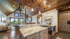 A spacious kitchen with a large island, wooden ceiling, and built-in appliances. - Campfire Trail at Eagles Nest - pet Friendly (Banner Elk)